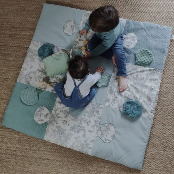 Le tapis d'éveil bleu, de petits fils et de coton