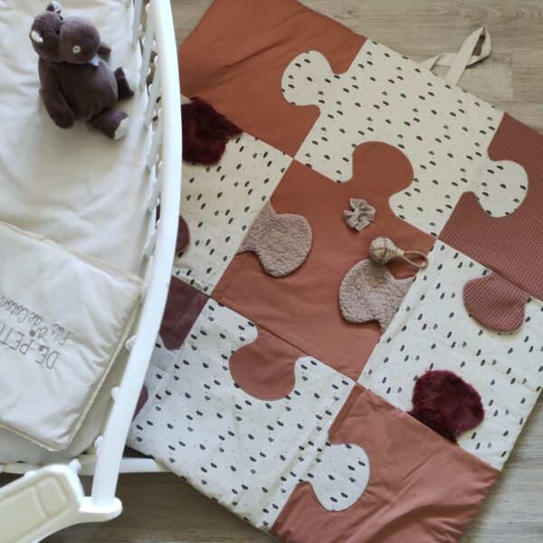 Le tapis d'éveil rose, de petits fils et de coton