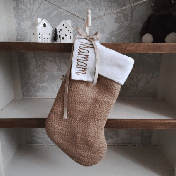 La botte de Noël traditionnelle, toile de jute beige, et fourrure blanche, de petits fils et de coton