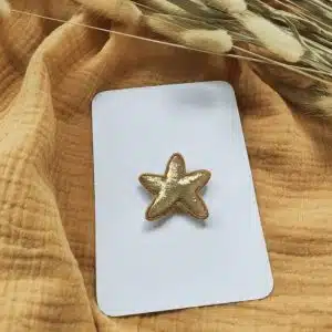 broche étoile dorée, de petits fils et de coton